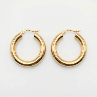 Gold hoop earrings on a light gray background