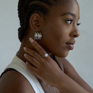 Mira Ribbed Dome Hoop Earrings in silver, extreme close-up on the ear detail