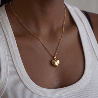 Perrie Faceted Heart Pendant Necklace worn on model, close-up on the faceted heart pendant